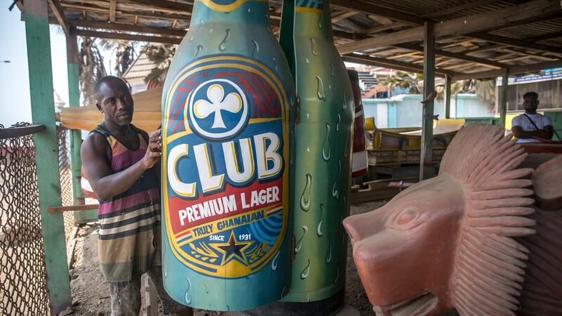 Coffin maker Eric Kpakpo stands by a beer bottle-shaped coffin at his workshop in Accra. Photograph: Sally Hayden
