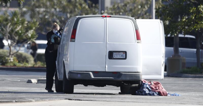 Investigators search a white van which police reported was connected with the  mass shooting at a dance studio in Monterey Park, California. Photograph: Caroline Brehman/EPA