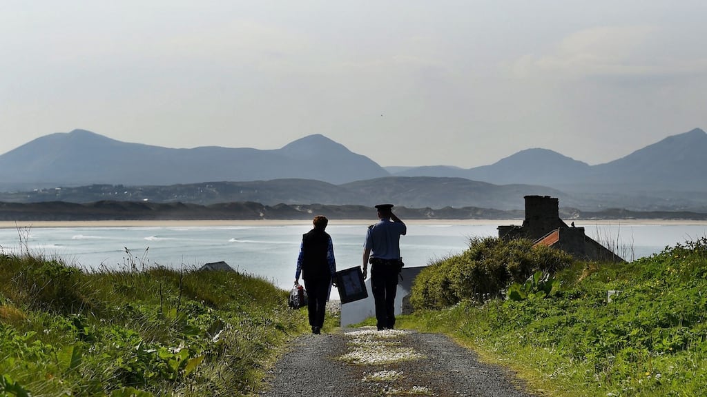 Presiding Officer Carmel McBride and Garda Alan Gallagher carry the polling box for the abortion referendum on Inishbofin. Photograph: Photograph: Reuters