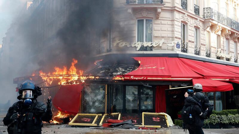 Famed Paris restaurant Fouquet’s burns on the Champs Elysees  during a yellow vests demonstration on Saturday. Photograph: Christophe Ena/AP Photo