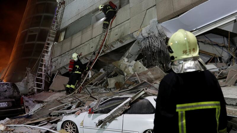 A fireman works at a collapses building after earthquake hit Hualien, Taiwan. Photograph: Tyrone Siu/Reuters