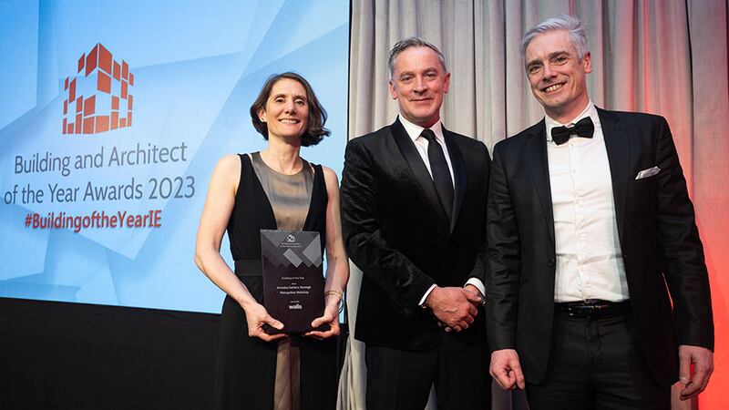 Barry Hennessy, business development and marketing director, Walls Construction, presents the building of the year award to Jonny McKenna and Denise Murray, Metropolitan Workshop