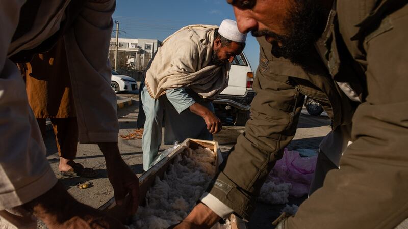 Distant relatives prepare the coffin for little  Sima. Photograph: Kiana Hayeri/ The New York Times