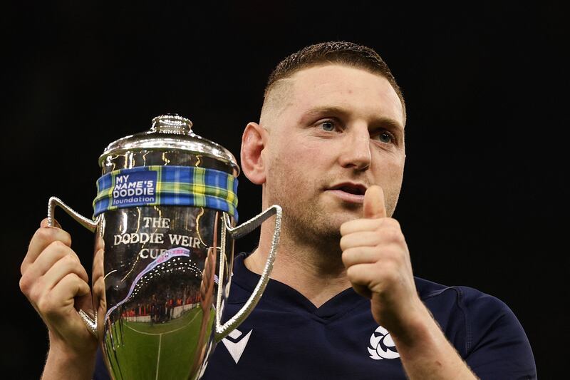 Scotland's outhalf Finn Russell celebrates with the Doddie Weir Cup. Photograph: Adrian Dennis/AFP via Getty