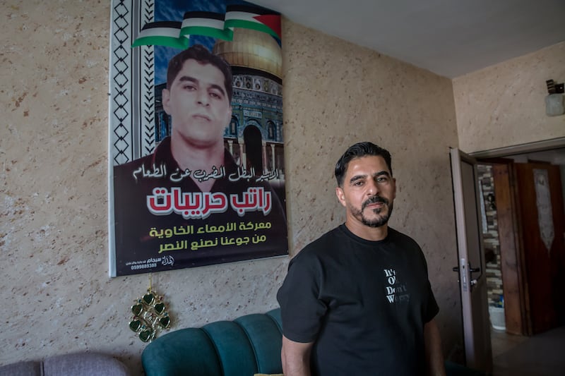 Ratib Hrebat stands in front of a poster created when he was on hunger strike in an Israeli prison. Photograph: Sally Hayden