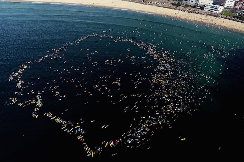 Members of the Bondi community paddle and swim into the ocean and form a circle to pay respect to victims, survivors and first responders of the December 14th Bondi shooting. Photograph: Cameron Spencer/Getty Images