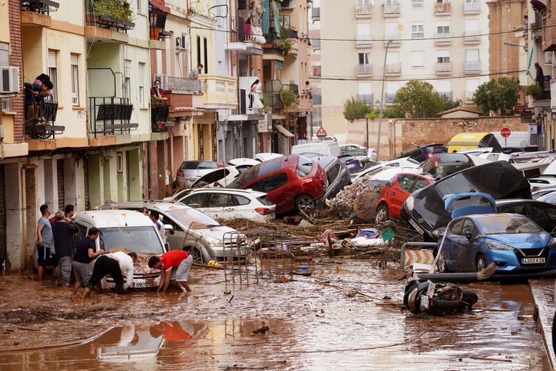 Spain floods: Residents look at cars piled up after being swept away by floods in Valencia. Photograph: Alberto Saiz/AP