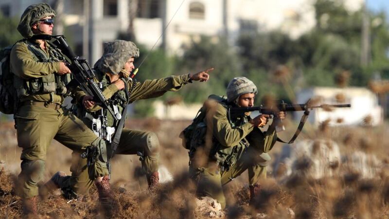 Israeli soldiers watch Palestinian protesters during clashes near  the Jalazoun Palestinian refugee camp. Photograph: Abbas Momaniabbas/AFP