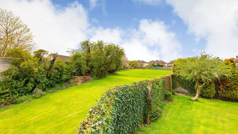 Rear garden opening into private grassy area.