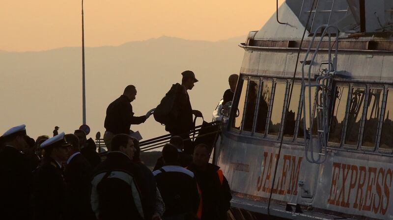 A migrant is escorted by a Frontex officer into a ferry in the port of Mytilene, Lesvos Island, Greece, Monday. Some 160 migrants, from Pakistan, Bangladesh and Morroco, who refused to apply for asylum, were  deported  early on Monday, after an agreement between the European Union (EU) and Turkey on the refugees crisis. Photograph: EPA