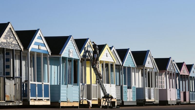 A man paints beach huts along the sea front at Southwold in Suffolk, as the UK  experienced its warmest winter day since records began with temperatures hitting 20.8C in Porthmadog, Gwynedd, west Wales on Tuesday: Photograph: Joe Giddens/PA Wire