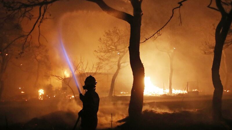 A firefighter battles the fire in the town of Mati, east of Athens. Photograph: Thanassis Stavrakis/AP