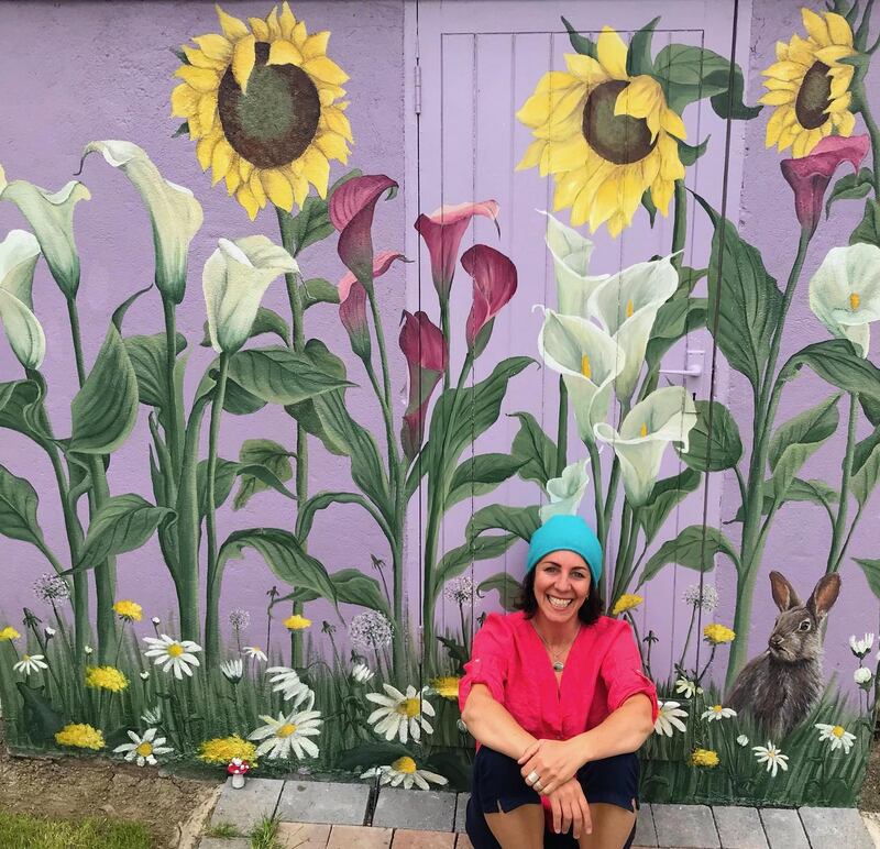 Vauney Strahan with one of her  murals on a garden shed
