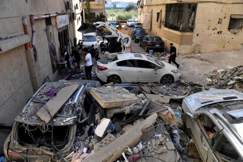 Members of Hizbullah gather near damaged vehicles following an Israeli airstrike that targeted an apartment in Choueifat, south of Beirut. Photograph: EPA