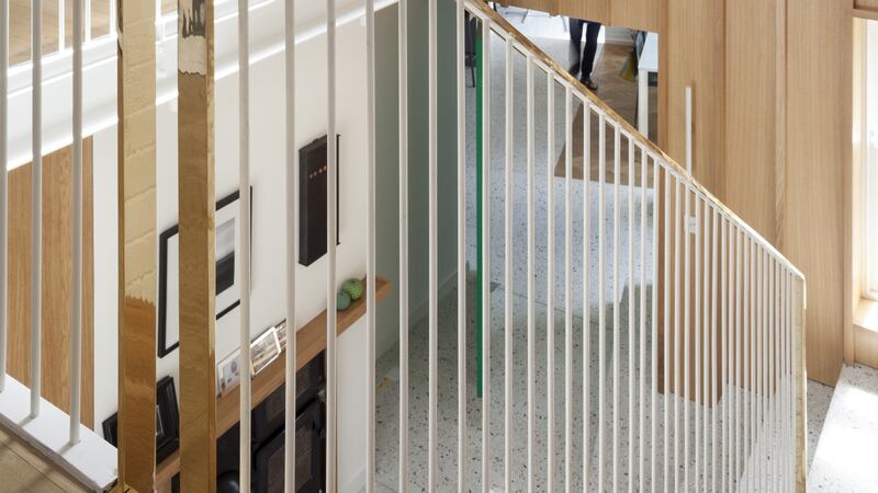 GKMP: a double-height stairwell with a lightweight-looking painted steel balustrade.