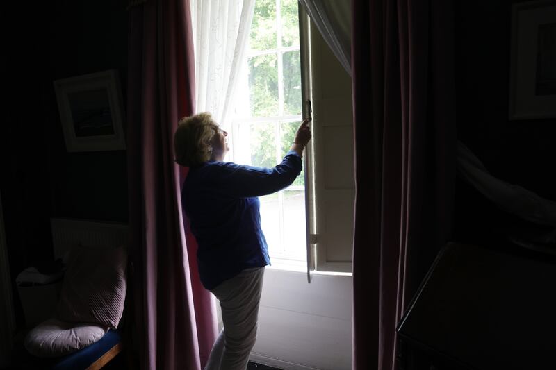 Dr Ina Kelly opens the wooden shutters in her home. The shutters are in place to keep rooms cool during particularly warm spells. Photograph: Bryan O’Brien/The Irish Times