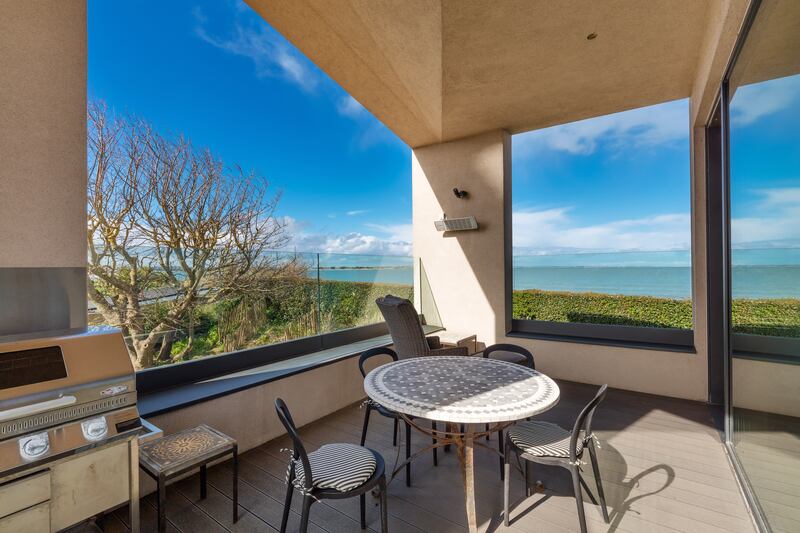Covered deck with glass balustrades on west side of house