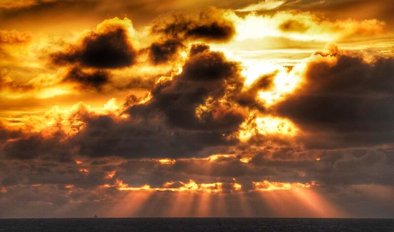 A  ferry on the horizon sails under stormy skies and sunlight off the coast of Whitley Bay, England. Photograph: Owen Humphreys/PA Wire