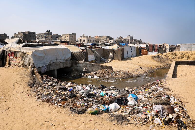 Displaced Palestinians in Deir al-Balah on the coast of the central Gaza Strip, next to rubbish and raw sewage on Monday. Photograph: Eyad Baba/AFP 