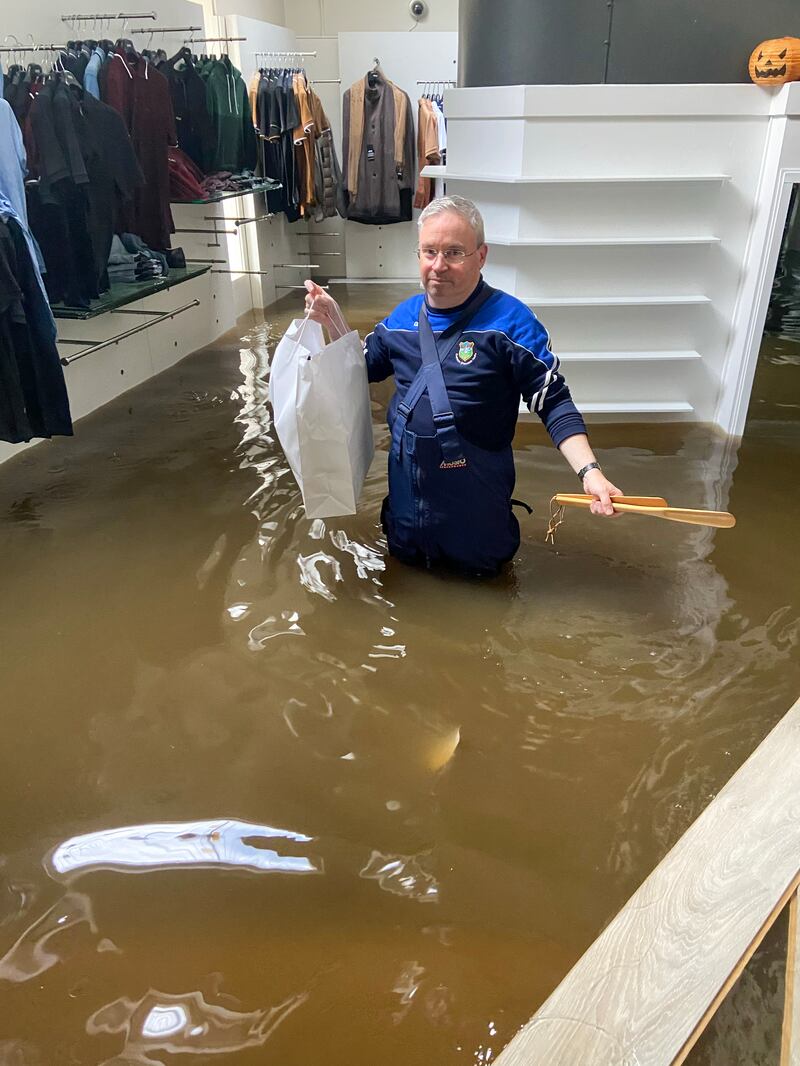 Paul McKibbon walking through flood water in McCartan Bros clothes store in Newry Town, Co Down on Tuesday evening. Photograph: Brendan Digney for PA