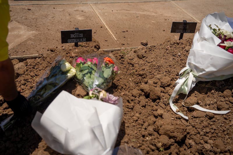 A worker rests flowers on the gravesites of Boris and Sofia Gurman at Rookwood General Cemetery in Sydney, Australia. They were among the victims of a mass shooting at Bondi Beach when they attempted to stop one of the gunmen. Photograph: Audrey Richardson/Getty Images