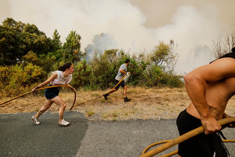 Local residents and volunteers attempt to douse an encroaching fire in Larouco, northwestern Spain. Photograph: Lalo R Villar/AP