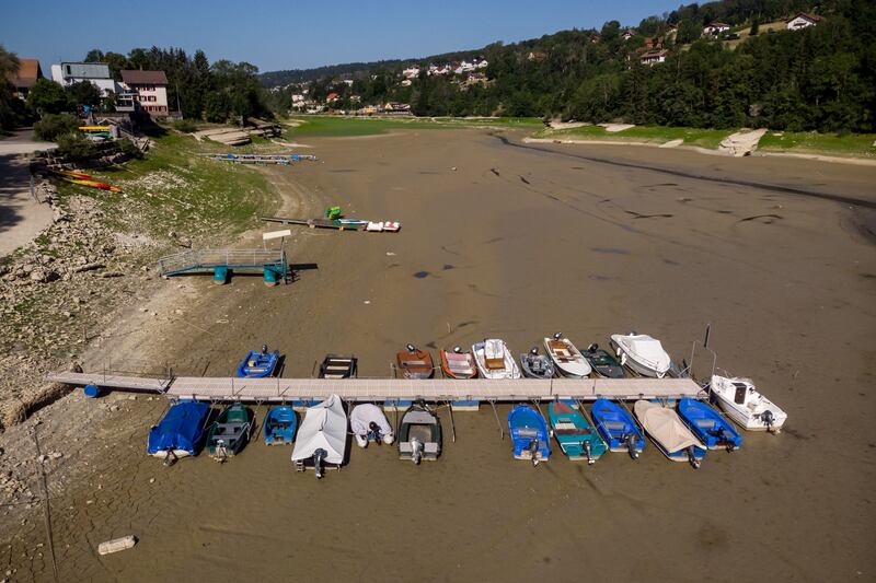 Boats sit on the dry bed of Brenets Lake (Lac des Brenets), part of the Doubs River, a natural border between eastern France and western Switzerland on Monday. The river has dried up due to  a combination of factors, including geological faults that drain the river, decreased rainfall and heat waves. Photograph: Fabrice Coffrini/Getty 