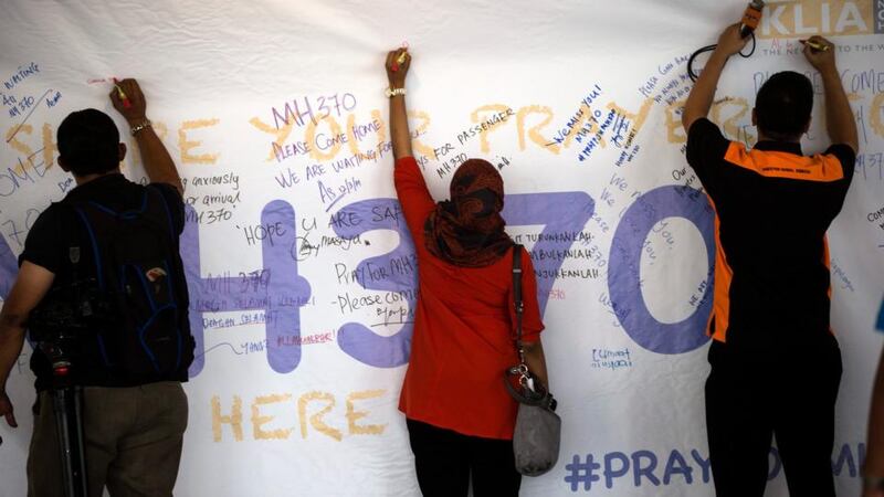 Journalists write  notes about the missing Malaysian Airlines flight on a board at Kuala Lumpur International Airport in Malaysia today. Photograph: Ahmad Yusni/EPA