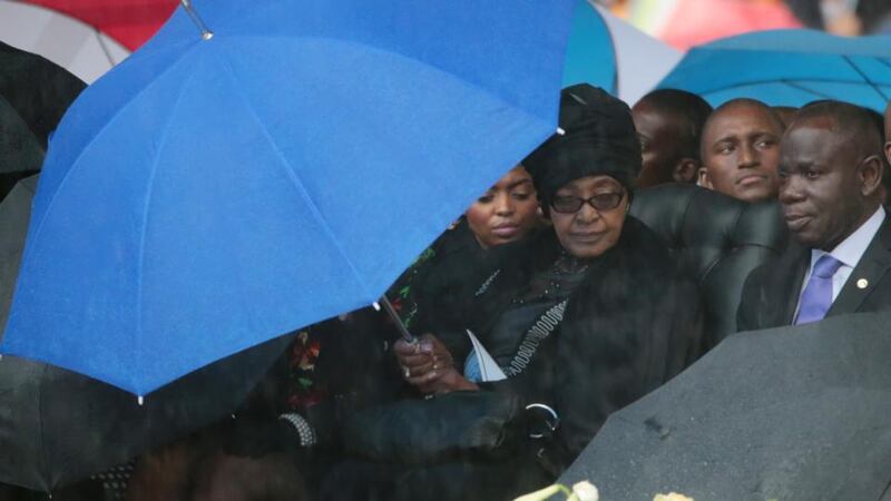 Winnie Madikizela-Mandela sits under an umbrella during the official memorial service for her ex husband and former South African President Nelson Mandela. Photograph: Christopher Furlong/Getty Images