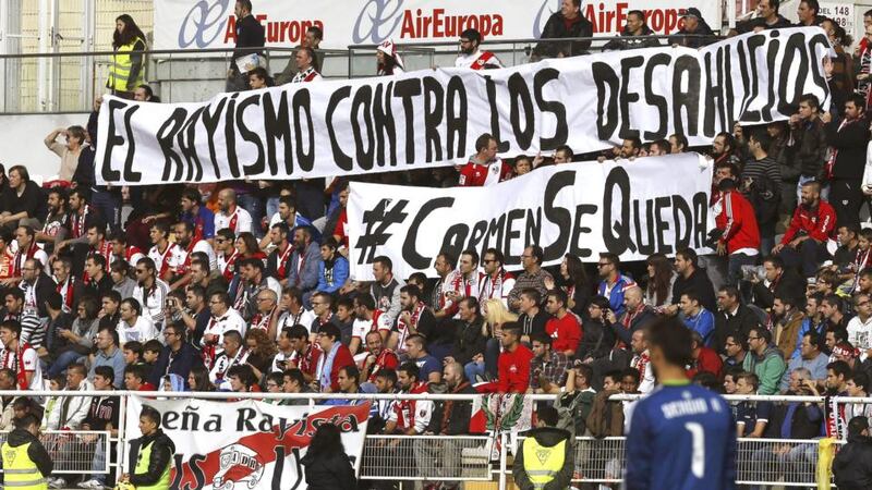 Rayo Vallecano fans hold a banner reading ‘Rayo’s fans against evictions’ and ‘#Carmen is staying’ during the club’s match against Celta Vigo at Vallecas Stadium in Madrid on Sunday. The club is to help Vallecas resident Carmen Martínez, who was evicted  from her house on November 21st. Photograph: Sergio Barrenechea/EPA