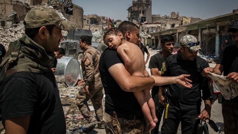 Iraqi special forces soldiers care for a child who was carried out of a final pocket still controlled by Islamic state fighters, in the Old City of Mosul, Iraq, July 12, 2017. Ivor Prickett/The New York Times
