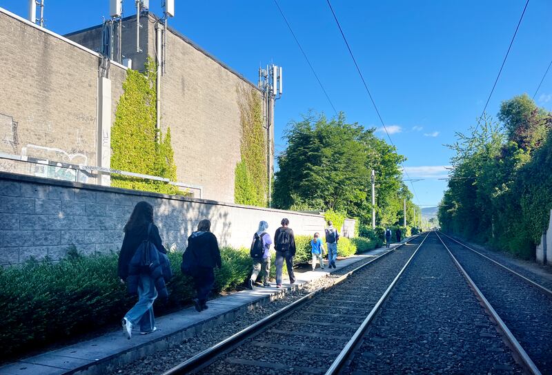 People walk along an access path next to the tracks near the Beechwood stop. Photograph: Bryan O’Brien/The Irish Times