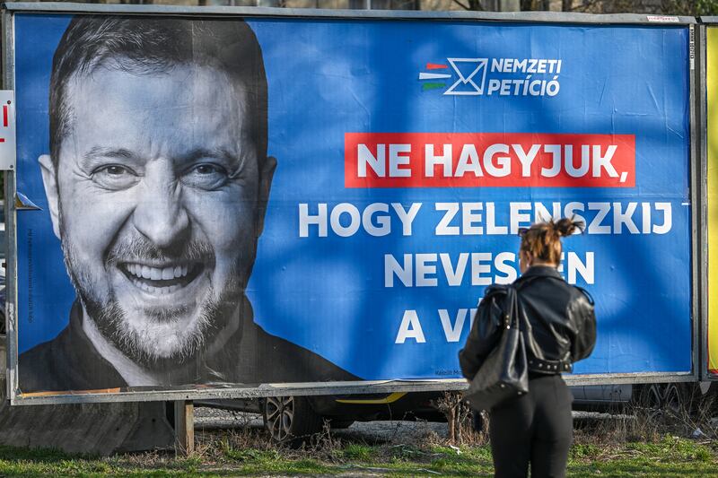 A woman walks past a pro-government billboard featuring a portrait of Ukrainian president with the text: "Let's not let Zelenskiy have the last laugh" in Budapest. Photograph: Attila Kisbenedek/AFP/Getty Images