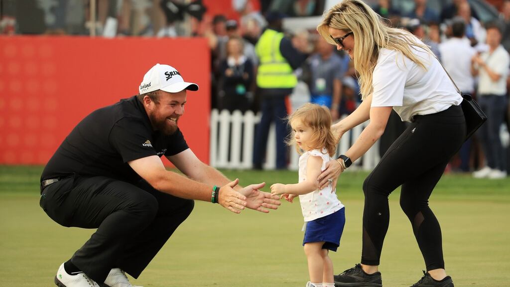 Shane Lowry celebrates with wife Wendy Honner and daughter Iris Lowry on the 18th green after winning the Abu Dhabi HSBC Golf Championship. Photo: Andrew Redington/Getty Images