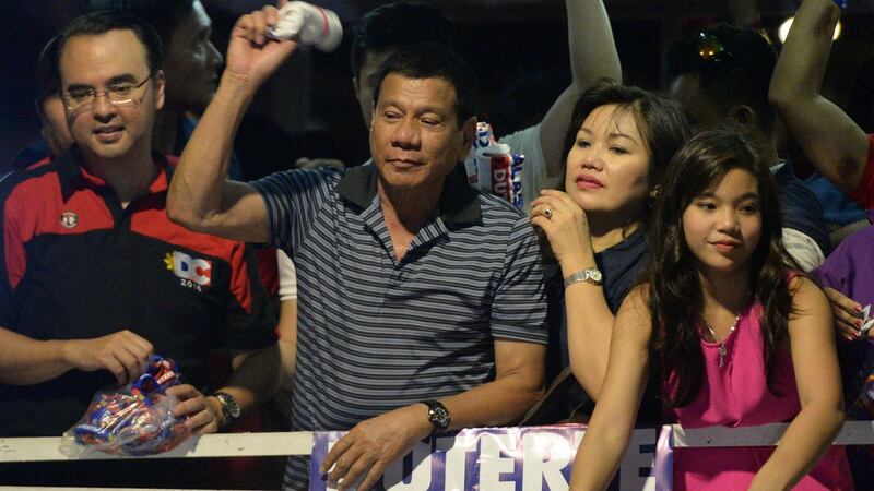 Philippine presidential candidate  Rodrigo Duterte, with his partner Honeylet and daughter Veronica,  throws a tee shirt to supporters  in the town of Silang, Cavite province, on April 22nd. Photograph: Ted Aljibe/AFP/Getty Images