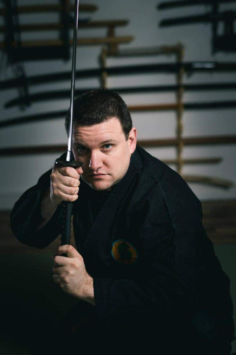 Alex Meehan holding a samurai katana