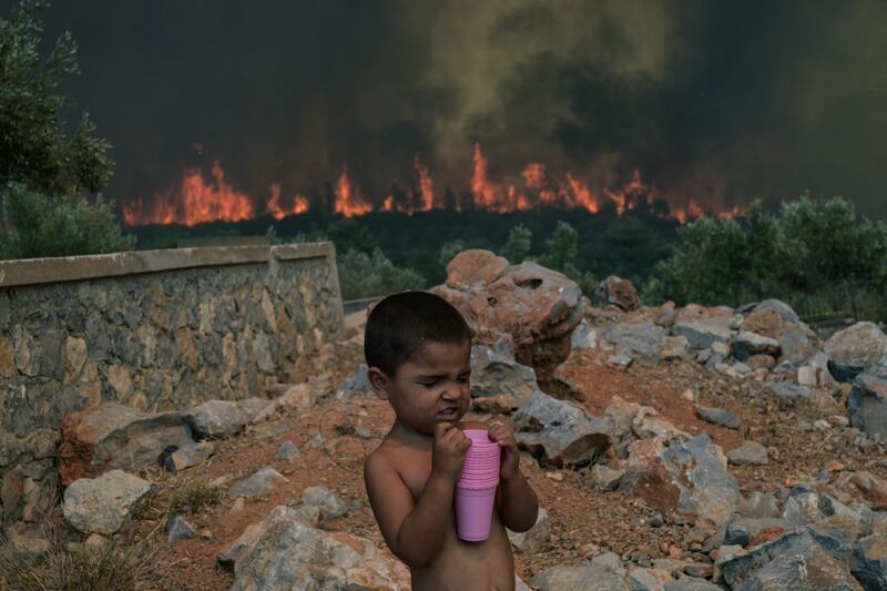 A child reacts as a wildfire burns, in the village of Agios Charalabos, near Athens, on July 18th, 2023. Photograph: Aris Messinis/AFP via Getty Images