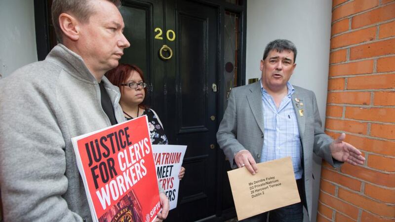 Gerry Markey, a  shop steward who has worked for 34 years at Clerys, delivers a letter to Deirdre Foley of Natrium, the new owners of Clerys, with other former staff  outside the Natrium offices on Harcourt Terrace on Friday.  Photograph: Fergal Phillips