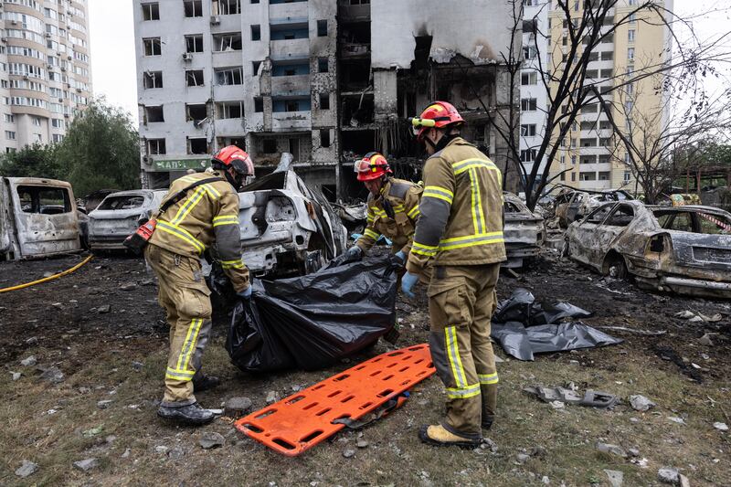 Firefighters prepare to carry a body from the scene of a Russian in Kyiv on Monday. Photograph: Paula Bronstein/Getty