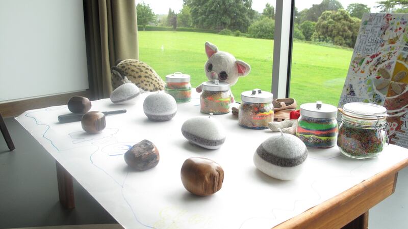 A table for the ceremony laden with a candle, work the children did with sand and other items of meaning to them