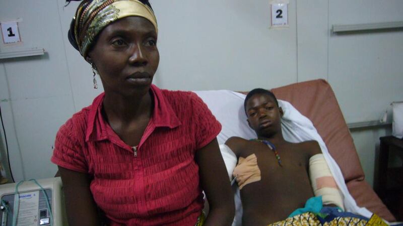Suffering: Justine Sanze with her 14-year-old son, Octave, who was hit in the back by a stray bullet. Photograph: Lara Marlowe