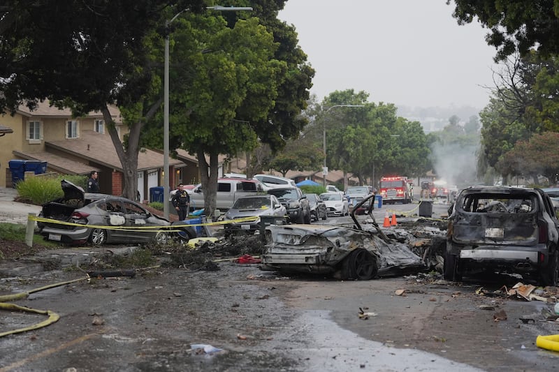 Aftermath of the aircraft impact in the neighbourhood, where vehicles and homes were damaged. Photograph: Gregory Bull/AP
