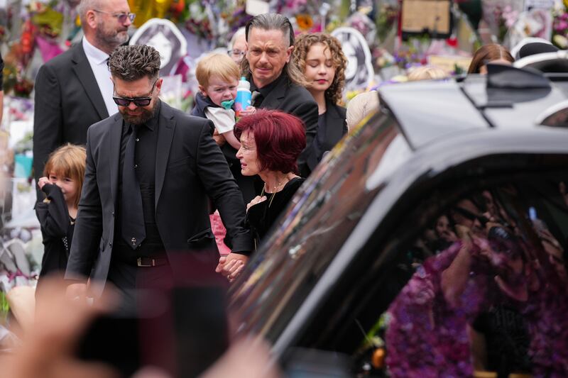 Jack Osbourne, Sharon Osbourne, Kelly Osbourne (hidden) and family members stop to view tributes to the late Ozzy Osbourne from fans. Photograph: Christopher Furlong/Getty Images
