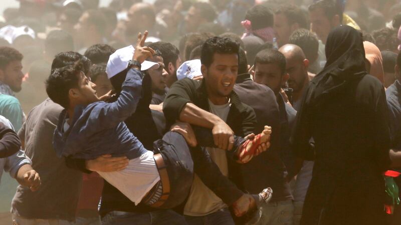 Palestinians carry a demonstrator injured during clashes with Israeli forces near the border between the Gaza strip and Israel east of Gaza City on Monday. Photograph:  Mahmud Hams/AFP/Getty Images