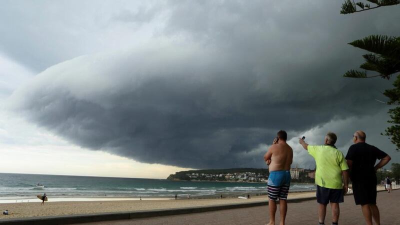 Storm clouds pass over Manly’s Fairy Bower beach on Sydney’s north shore as locals (L-R) Matt Fleming, Larry McMurridge and George Stantschef look on. Photograph: Will Burgess /Reuters