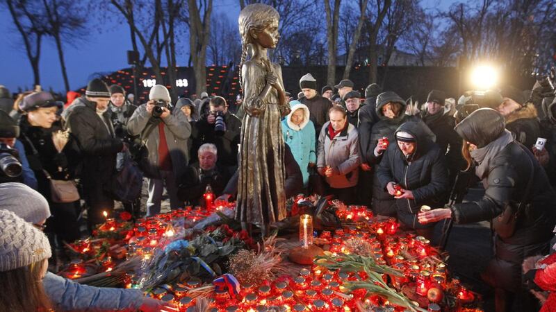 Ukrainians place candles and spikelets of wheat at the monument  marking the Holodomor of 1932-33 in Kyiv in 2019. Photograph: Pavlo Gonchar/Sopa Images/LightRocket via Getty Images