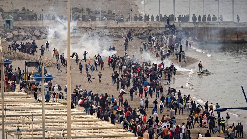Tear gas fumes fill the air as Spanish security forces watch Moroccan migrants near a border fence in the northern town of Fnideq in an attempt to cross the border into Ceuta. Photograph:  Fadel Senna/AFP via Getty Images