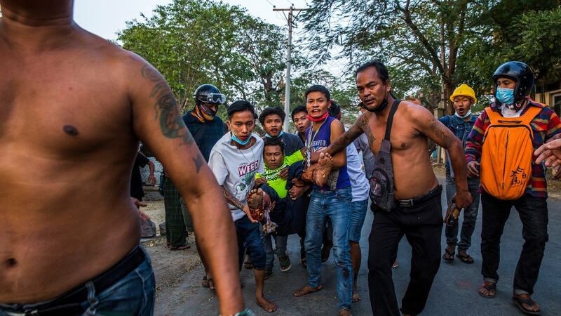 Protesters carry a man who was shot by security forces during a protest in Mandalay on February 28th. Photograph:  The New York Times