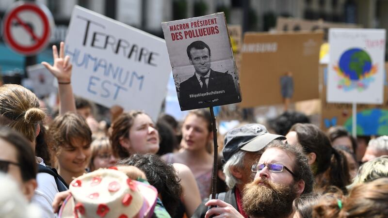 A demonstrator with  a portrait of  Emmanuel Macron with the words ‘Macron, President of polluters’, during a protest calling on the French government to act against climate change.  Photograph: Alain Jocard/AFP/Getty Images