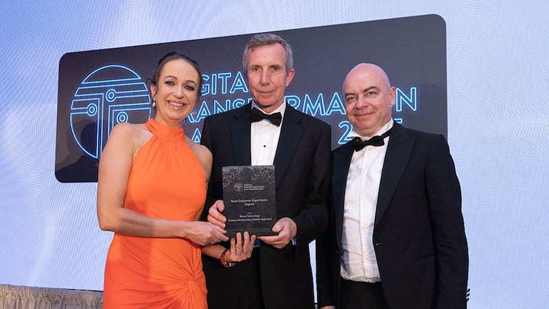 Cliona McParland, awards judge, presents the best customer experience impact to Karl Flannery and Brian Quinn, Storm Technology